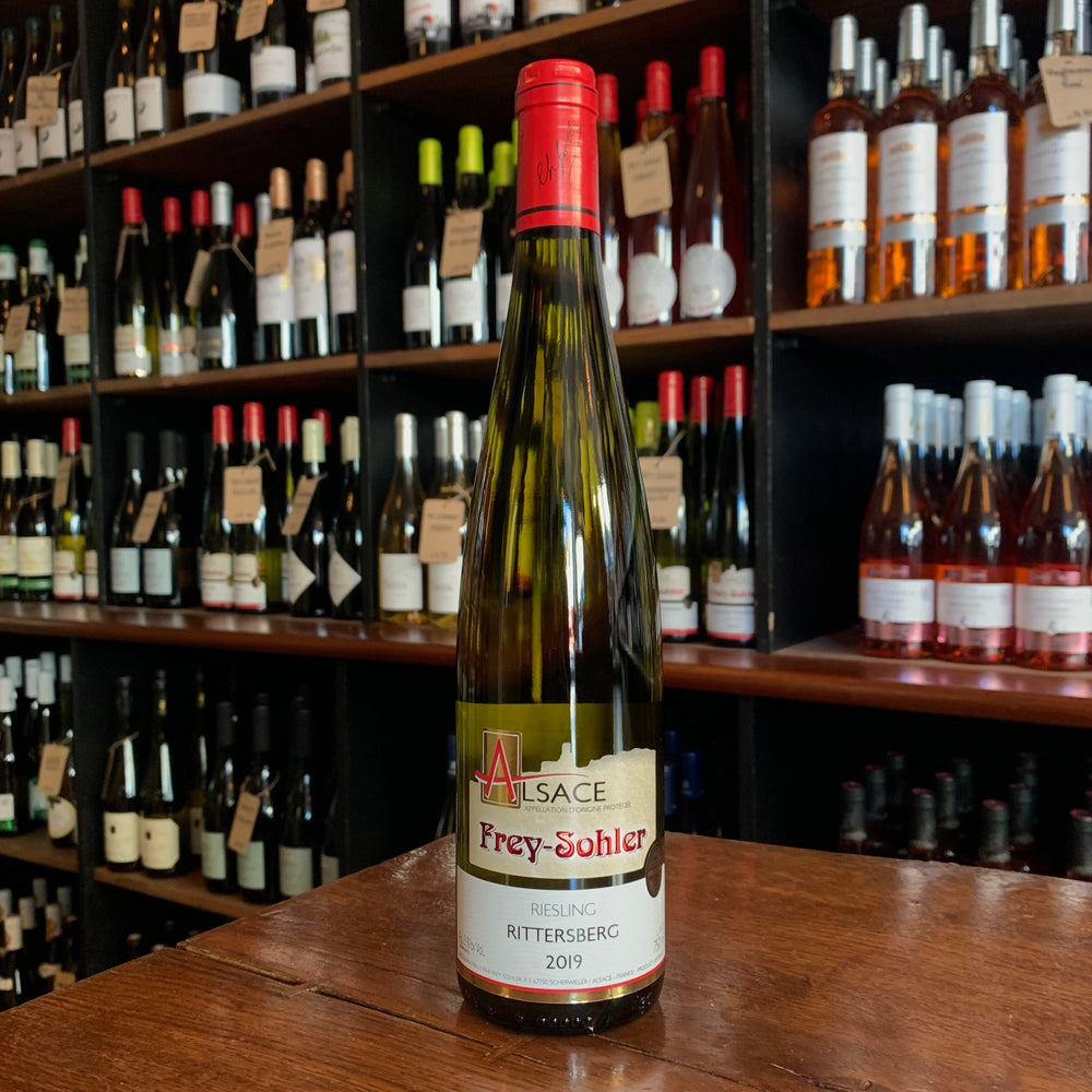 bottle of wine standing on a wooden table with its label facing