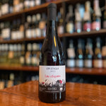 bottle of wine standing and label facing on a wooden table